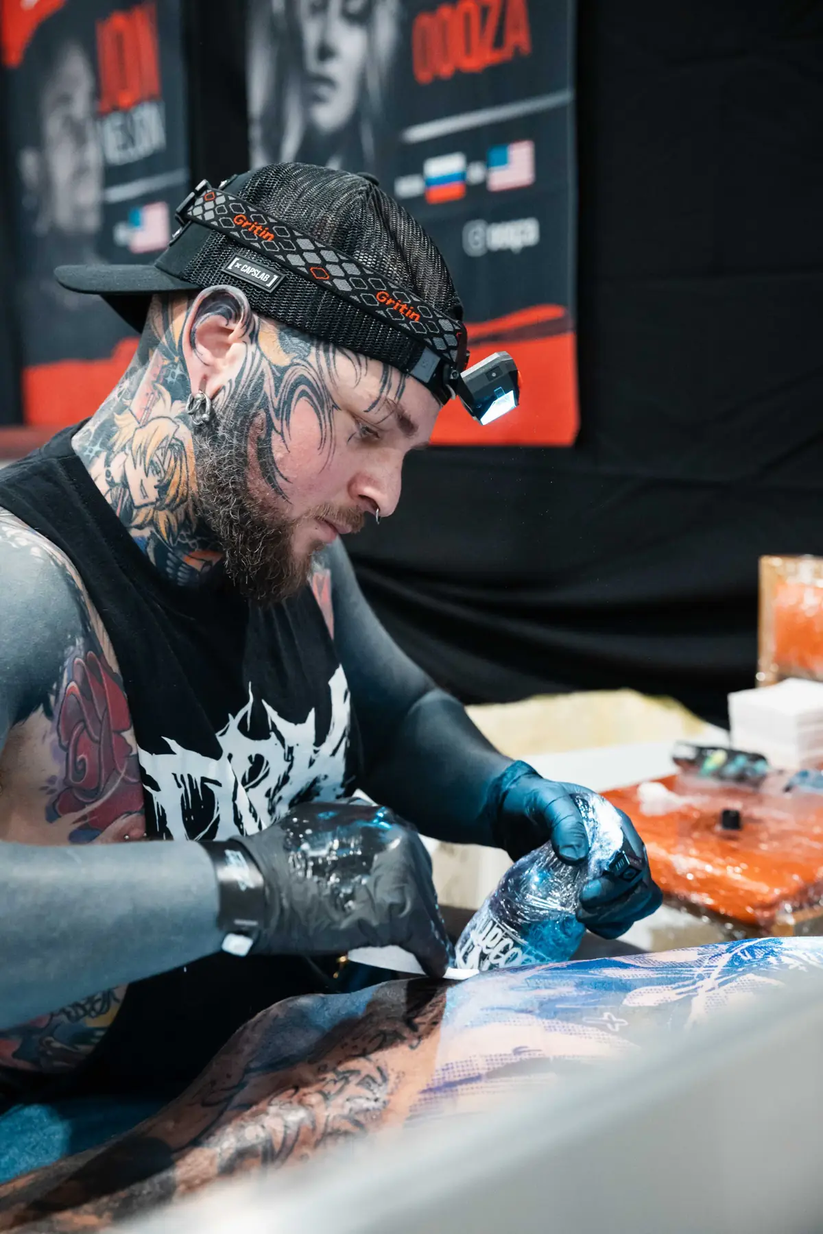 Tatuador em sessão no estande